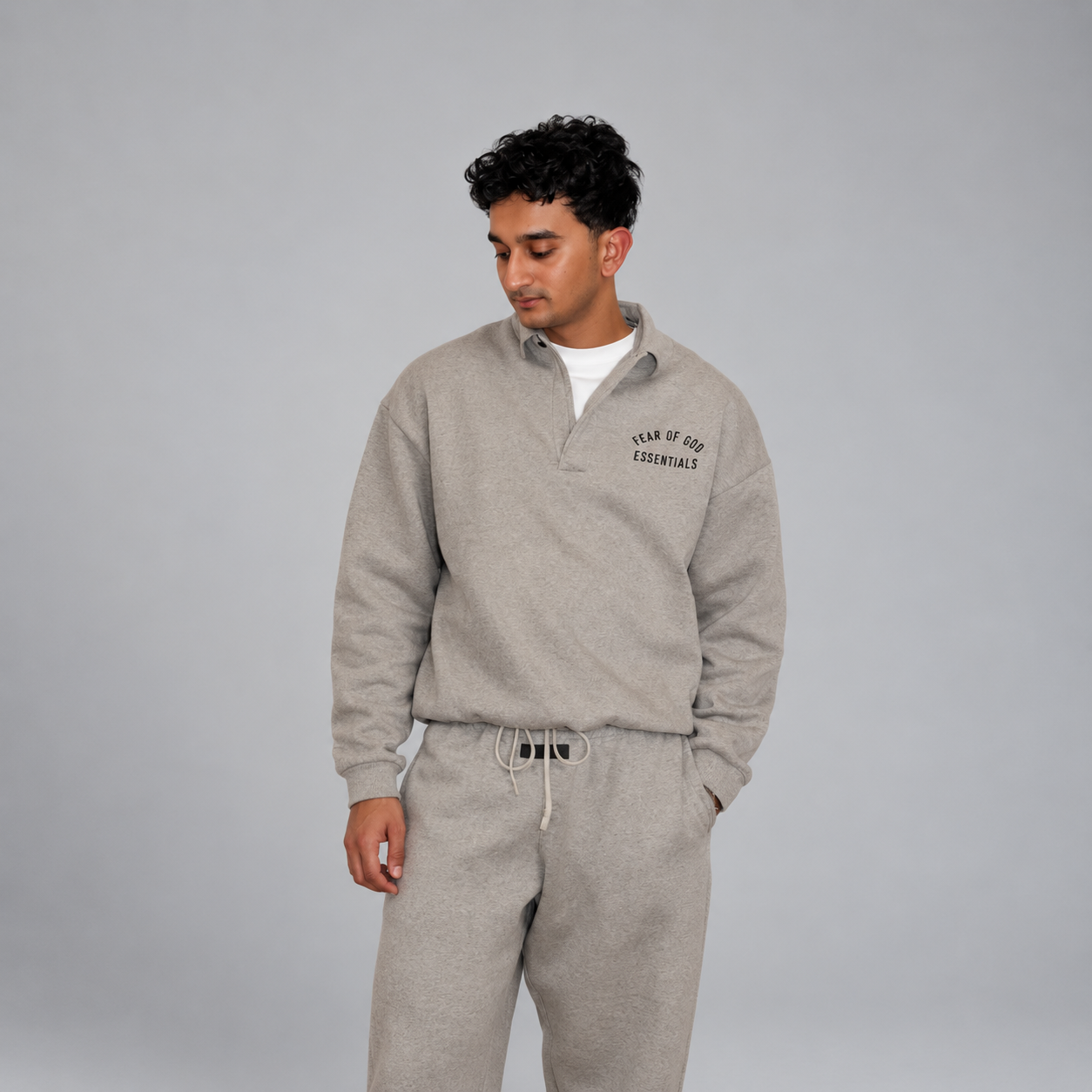 Man wearing a gray Essentials outfit against a soft gray studio background
