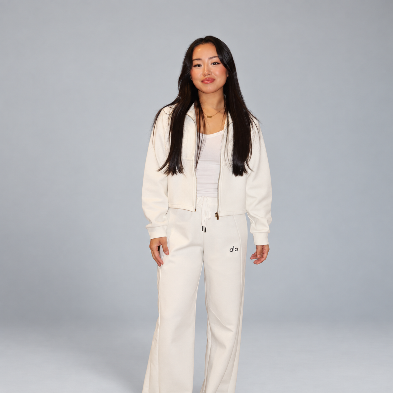 Woman wearing an ivory outfit against a soft gray studio background